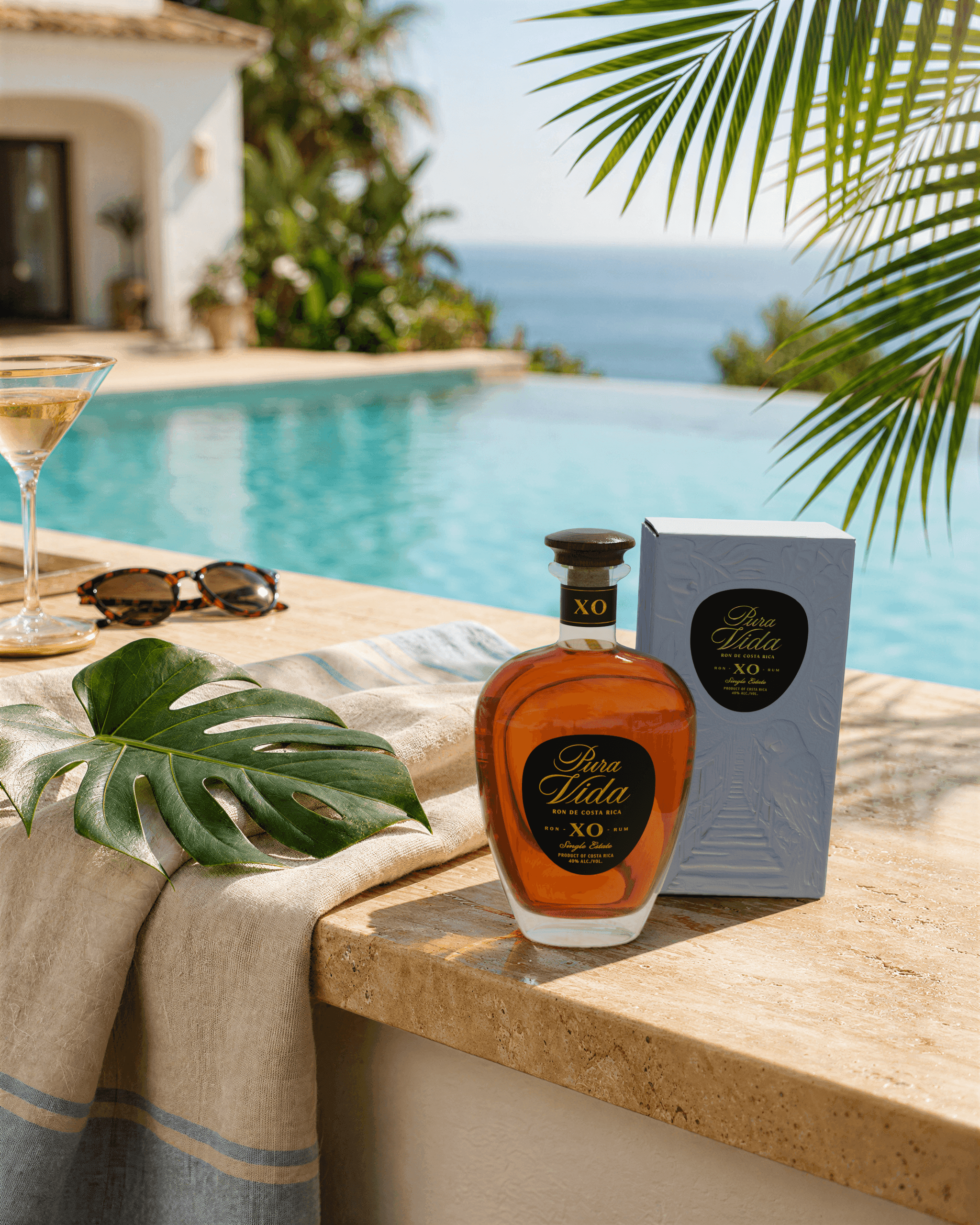 Ron Matusalem rum bottle and box beside an infinity pool with an ocean view.