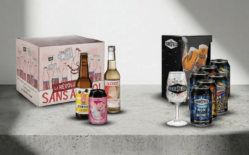 Collection of assorted alcoholic and non-alcoholic beverages, including bottles, cans, and a branded glass.