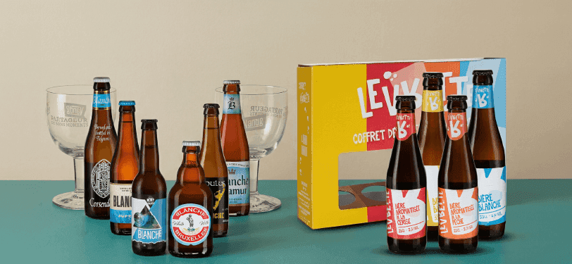 Brown beer bottles, two empty glasses, and a colorful beer gift box.