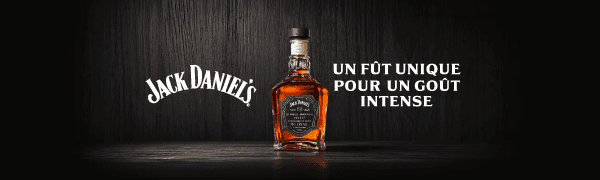 Jack Daniel's whiskey bottle in a dark setting, with text about unique barrel and intense taste.