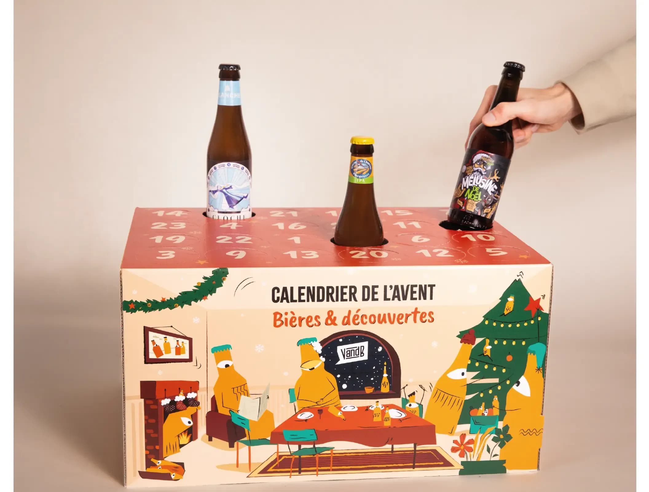 A hand places a dark beer bottle into a festive red advent calendar box with other beers.